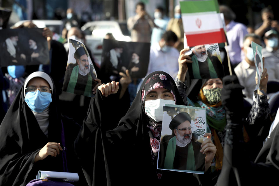 Supporters of presidential candidate Ebrahim Raisi hold signs during a rally in Tehran, Iran, Wednesday, June 16, 2021. Iran's clerical vetting committee has allowed just seven candidates for the Friday, June 18, ballot, nixing prominent reformists and key allies of President Hassan Rouhani. The presumed front-runner has become Ebrahim Raisi, the country's hard-line judiciary chief who is closely aligned with Supreme Leader Ayatollah Ali Khamenei. (AP Photo/Ebrahim Noroozi)