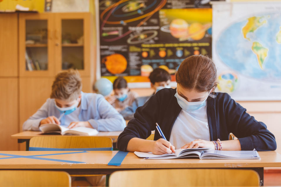 High school students at school, wearing N95 Face masks. Sitting in a classroom.