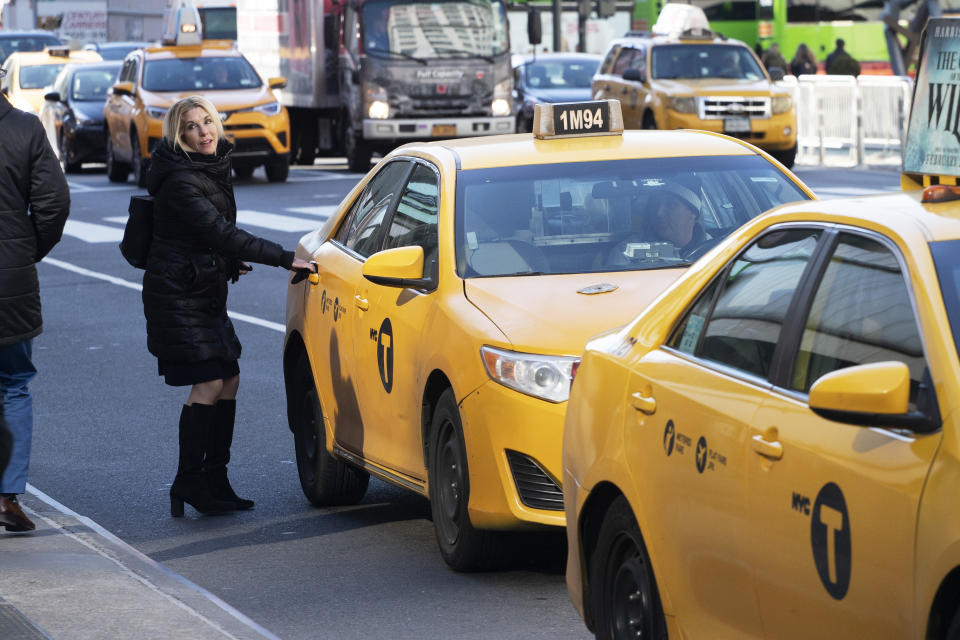 A passenger gets into a taxi, Wednesday, Jan. 29, 2020, in New York. A task force studying New York City's struggling taxi industry called Friday for “mission-driven” investors to help bail out drivers who incurred massive debt once the value of the medallion that allows a person to operate a yellow cab plummeted in the age of Uber and Lyft. (AP Photo/Mark Lennihan)