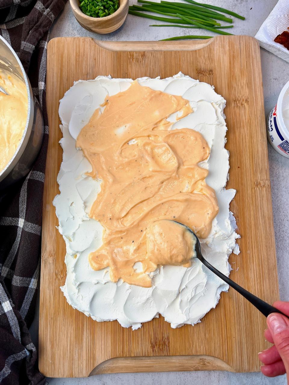 Layer your potato skin board with cream cheese, sour cream and homemade cheese sauce.