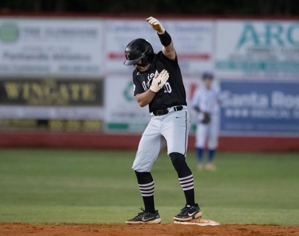 Jackson Penton (10) gestures to his teammates after hitting a stand up double during the Tate vs Pace 6A District 1 championship baseball game at Pace High School on Thursday, May 5, 2022.