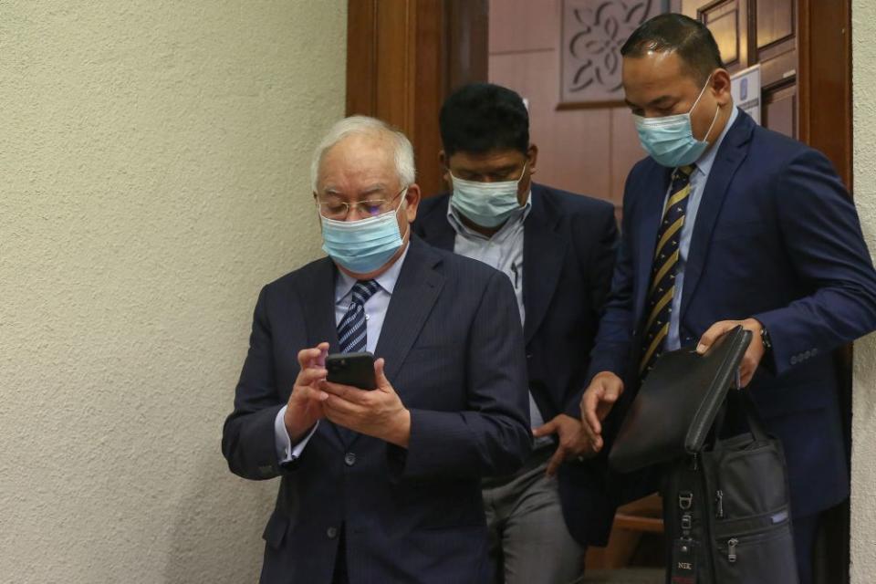 Datuk Seri Najib Razak checks his phone at the Kuala Lumpur High Court January 6, 2021.  — Picture by Yusof Mat Isa