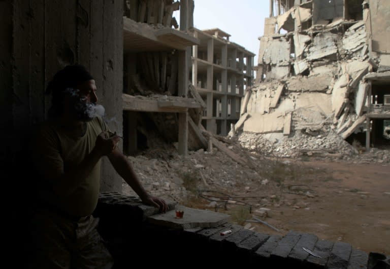 A Syrian fighter from a Turkish-backed rebel coalition stares at a damaged street in al-Rashidin, western Aleppo province, close to Idlib province and part of the country's last major opposition stronghold, on October 15, 2018