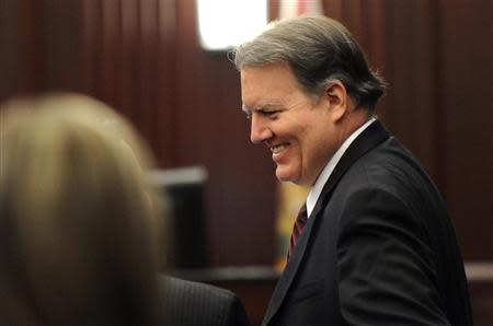 A smiling Michael Dunn talks with his lawyer Cory Strolla after the jury began their deliberations in Jacksonville, Florida February 15, 2014. REUTERS/Bob Mack/Florida Times-Union/Pool