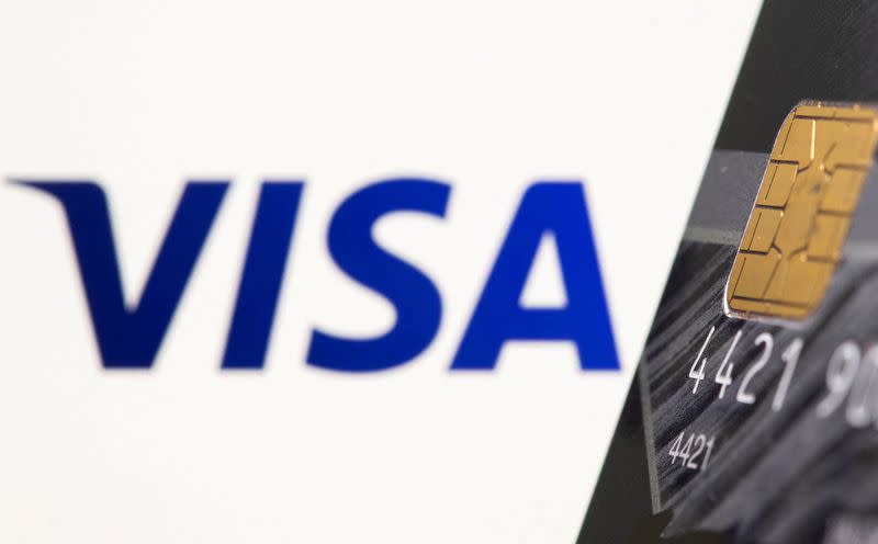 Foto de archivo: Una tarjeta de crédito se ve delante de un logotipo de Visa mostrado en esta ilustración