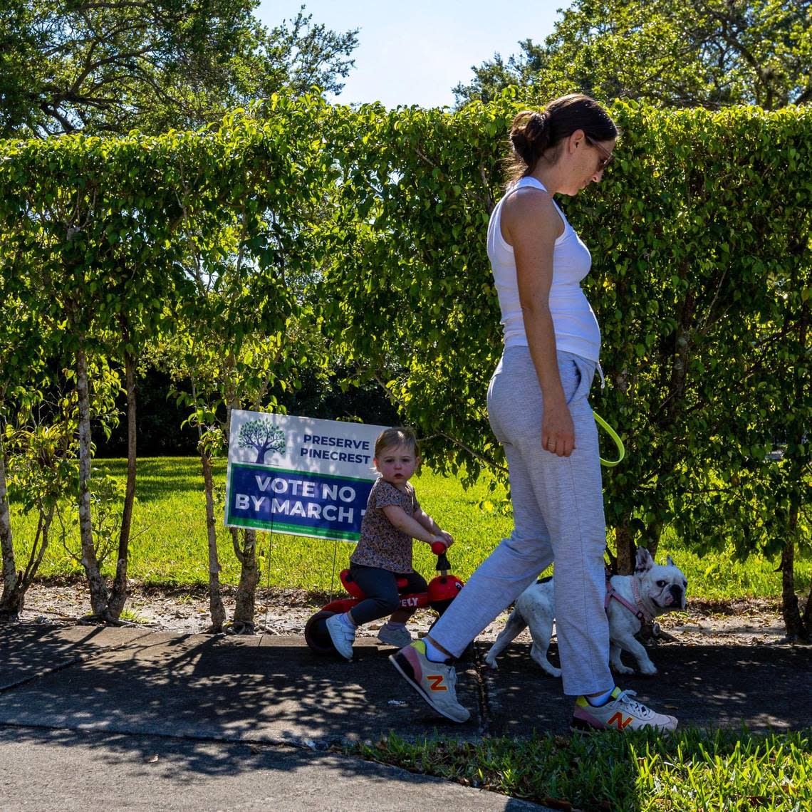 Pinecrest resident Corinne Bonner and her daughter Kiera and her dog Piggy walk past a sign that reads ‘VOTE NO’ in front of a resident’s yard in Pinecrest, Florida, on Wednesday, March 1, 2023. Bonner explained she already voted no on the new referendum.