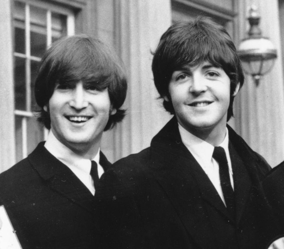 John Lennon, left, and Paul McCartney during a ceremony at Buckingham Palace in London on October 26, 1965.  / Credit: AP