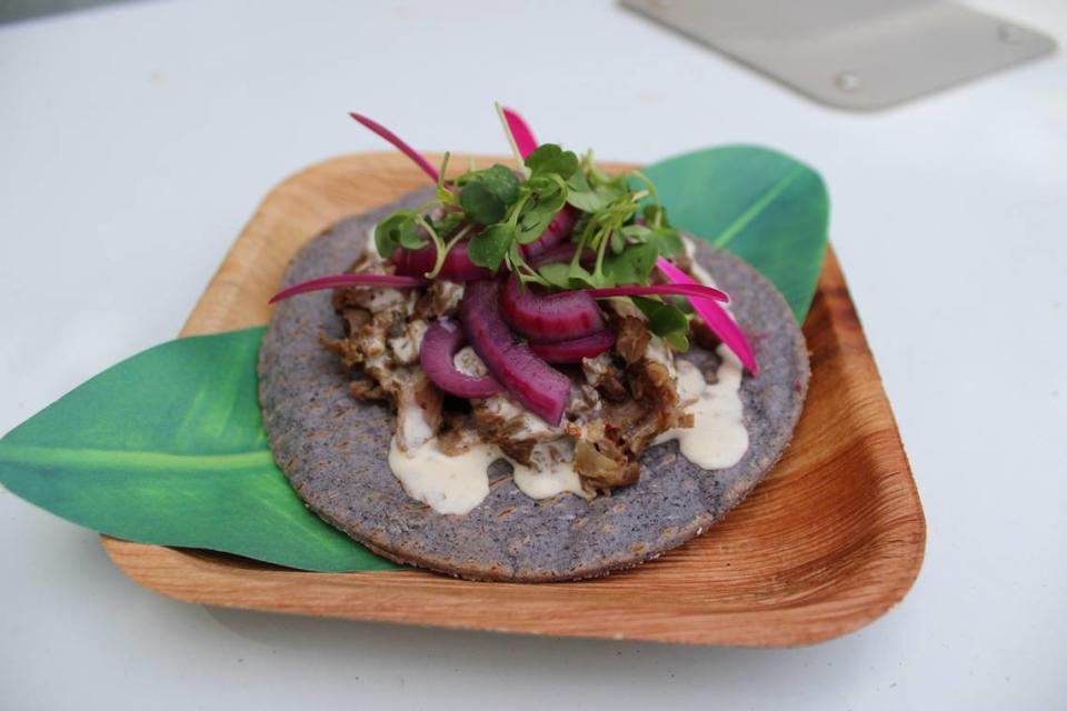 This dish from Luckybee Kitchen is togarashi lamb shank and roasted grape tostada on a palm leaf plate, topped with roasted grapes, chimichurri crema, microgreens and flower garnish.