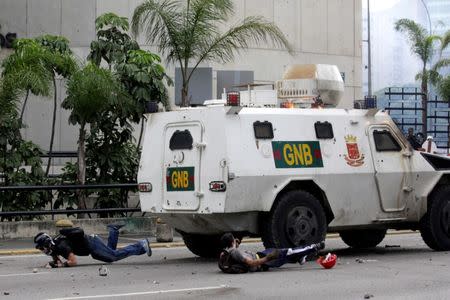 Demonstrators fall on the ground after being hit by a riot police armoured vehicle while clashing with the riot police during a rally against Venezuelan President Nicolas Maduro in Caracas, Venezuela, May 3, 2017. REUTERS/Marco Bello/Files