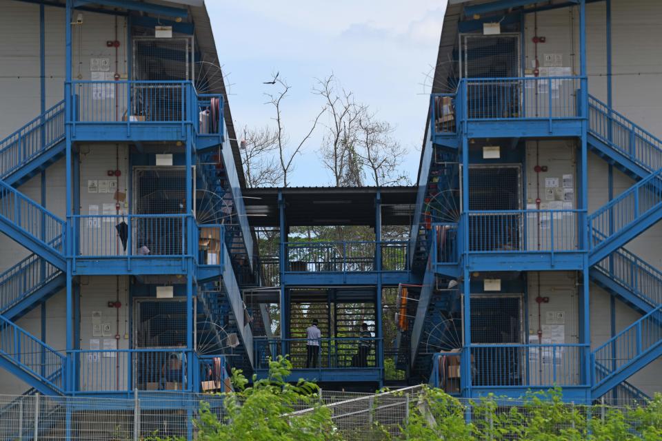 Migrant workers are seen resting at balcony after lunch time at the dormitories that houses foreign workers and has been made into an isolation area to prevent the spread of the COVID-19 coronavirus in Singapore on April 22, 2020. (Photo by Roslan RAHMAN / AFP) (Photo by ROSLAN RAHMAN/AFP via Getty Images)