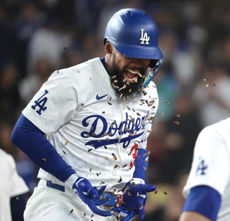 Teoscar Hernández gets a face full of sunflower seeds as he celebrates with his teammates after hitting a solo home run.