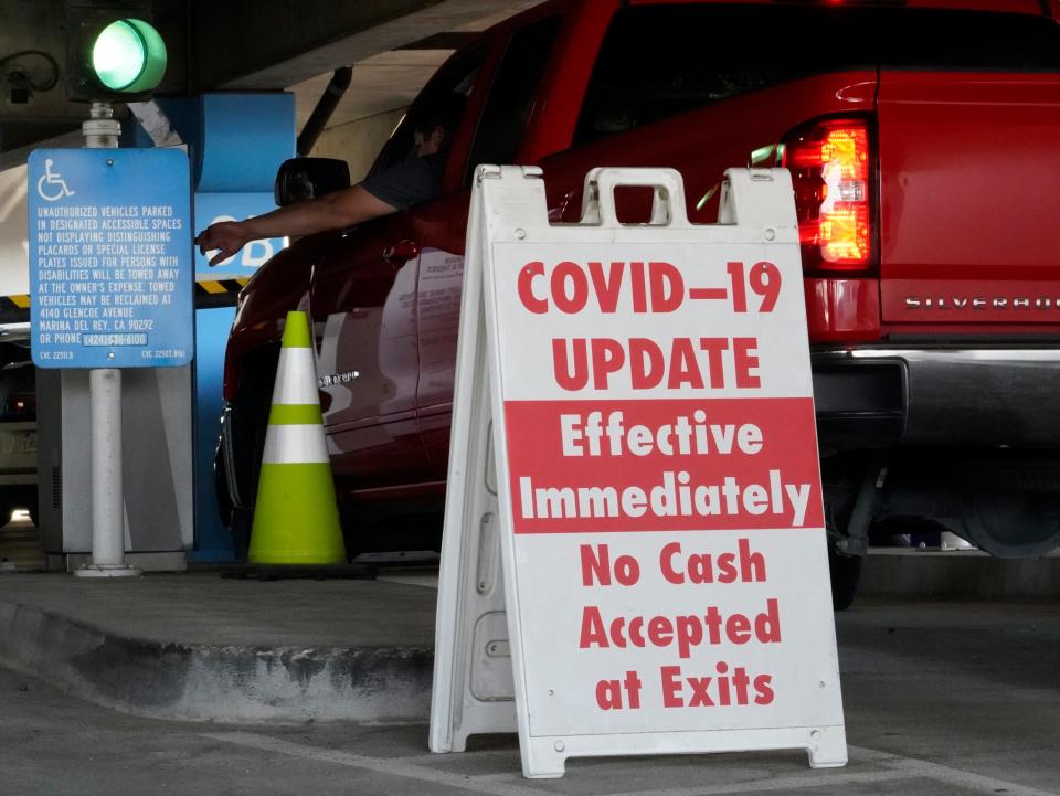 A sign posted reads "Covid-19 Update. Effective Immediately. No Cash Accepted at Exits," at a Los Angeles International Airport main parking lot in Los Angeles, Friday, Nov. 13, 2020.