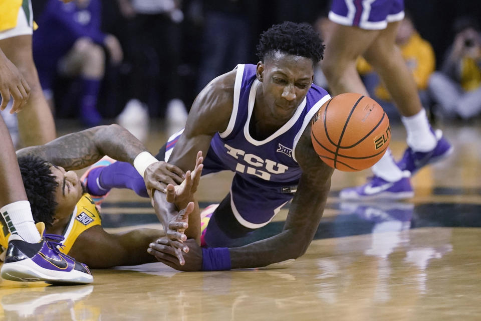 TCU guard Damion Baugh, right, and Baylor guard Langston Love (13) scramble for the ball during the first half of an NCAA college basketball game in Waco, Texas, Wednesday, Jan. 4, 2023. (AP Photo/LM Otero)