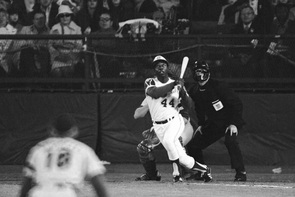 FILE - Atlanta Braves' Hank Aaron eyes the flight of the ball after hitting his 715th career homer in a game against the Los Angeles Dodgers in Atlanta, Ga., in this Monday night, April 8, 1974, file photo. Aaron broke Babe Ruth's record of 714 career home runs. Dodgers southpaw pitcher Al Downing, catcher Joe Ferguson and umpire David Davidson look on. (AP Photo/Harry Harrris)