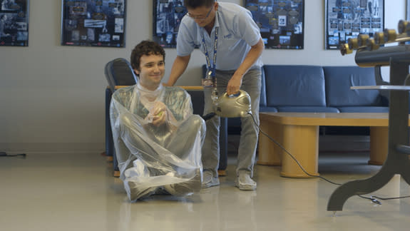 Science educator Tien Huynh-Dinh at the LIGO Science Education Center vacuum-wraps audio engineer Joe Chilcott in a demonstration of the atmospheric pressure humans live with, every day, on this planet at the LIGO Observatory in Livingston,