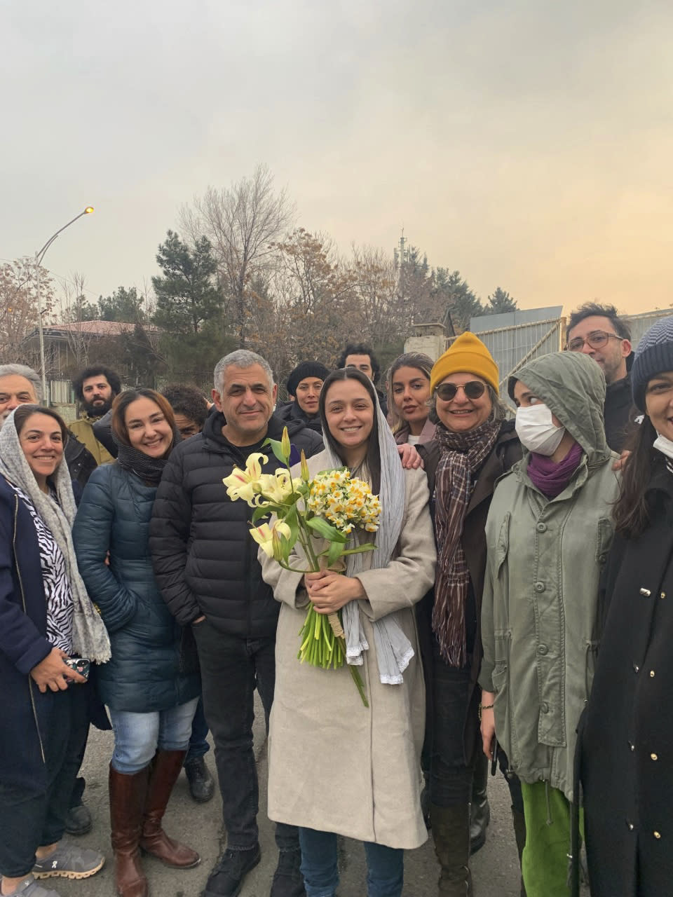 Iranian prominent actress Taraneh Alidoosti, center, holds bunches of flowers as she poses for a photo among her friends after being released from Evin prison in Tehran, Iran, Wednesday, Jan. 4, 2023. Iran released Alidoosti, a prominent actress from an Oscar-winning film, nearly three weeks after she was jailed for criticizing a crackdown on anti-government protests. (Gisoo Faghfouri, Sharghdaily, via AP)