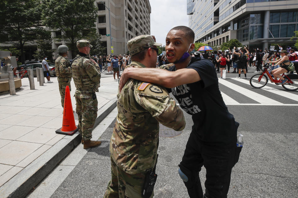 FILE - In this June 6, 2020, file photo, a demonstrator hugs a National Guard soldier during a protest in Washington, over the death of George Floyd, a black man who was in police custody in Minneapolis. The National Guard has designated military police units in two states to serve as rapid reaction forces in order to be better prepared to respond quickly to civil unrest around the country, in the wake of the violent protests that rocked the nation’s capitol and several states this summer. (AP Photo/Alex Brandon, File)