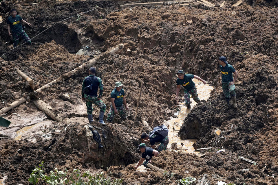 Rescuers dig through mud as they search for victims of an earthquake-triggered landslide in Cianjur, West Java, Indonesia, Wednesday, Nov. 23, 2022. More rescuers and volunteers were deployed Wednesday in devastated areas on Indonesia's main island of Java to search for the dead and missing from an earthquake that killed hundreds of people. (AP Photo/Tatan Syuflana)
