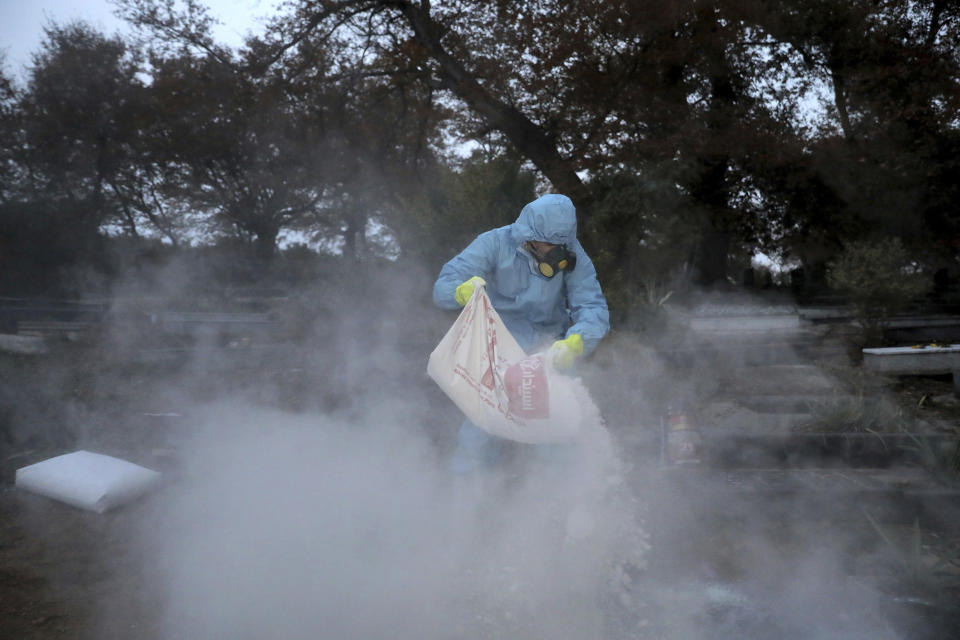 Mohammad Golestani a volunteer prepares a grave for a funeral of Rahmatollah Zakeri, 70, who died from COVID-19 at a cemetery in the Arateh village on the outskirts of the city of Ghaemshahr, in northern Iran, Wednesday, Dec. 16, 2020. (AP Photo/Ebrahim Noroozi)