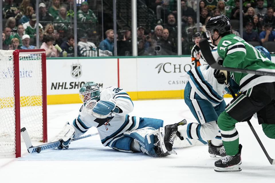 San Jose Sharks goaltender Magnus Chrona (30) makes a save as Dallas Stars' Ty Dellandrea (10) watches during the first period of an NHL hockey game in Dallas, Saturday, March 2, 2024. (AP Photo/Tony Gutierrez)