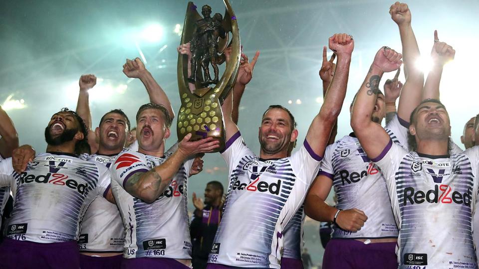 Melbourne Storm players, pictured here celebrating with the NRL premiership trophy.