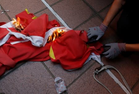 An anti-government protester burns a Chinese flag during a protest in Tuen Mun, Hong Kong