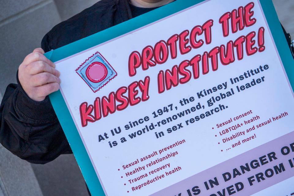 Indiana University graduate student Rory Barron holds a sign in support of the Kinsey Institute at the Sample Gates last week.