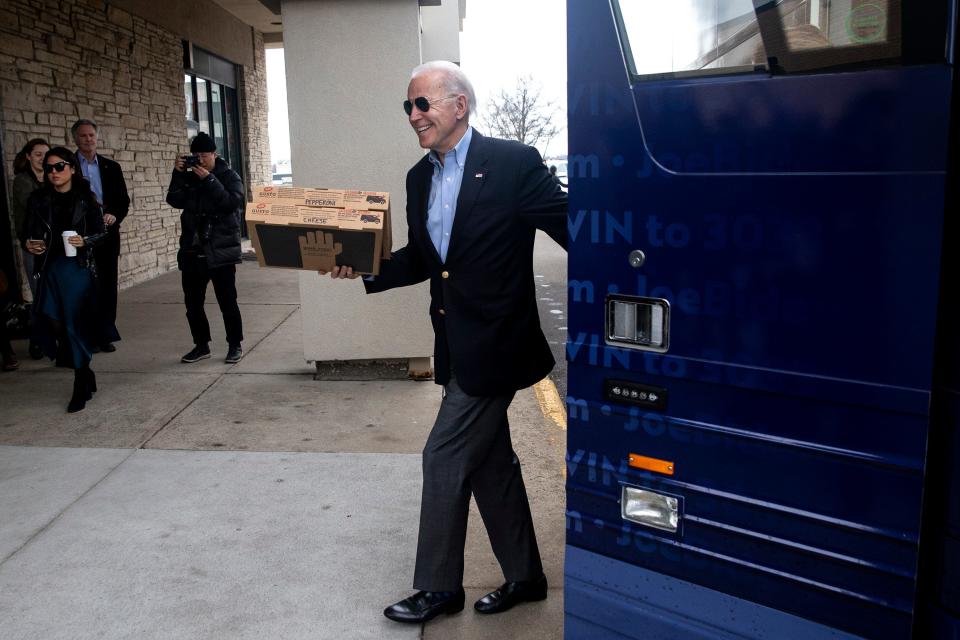 Former Vice President and Democratic presidential candidate Joe Biden delivers pizza to volunteers at his Des Moines campaign office.