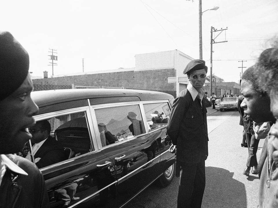 Black Panthers stand guard while the hearse carrying the body of George Jackson was brought to St. Augustine's Episcopal Church.