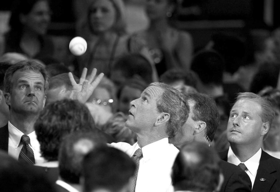 <p>President Bush reaches out to catch a baseball belonging to a young audience member, Sarah Sutherland, unseen. He later signed it following a question-and-answer session at Kutztown University in Kutztown, Pa., July 9, 2004. (Photo: Jacqueline Larma/AP) </p>