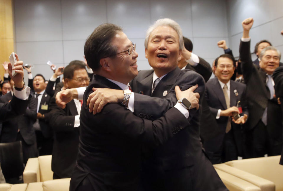 Japan's Economy, Trade and Industry Minister Hiroshige Seko,left, and head of 2025 Japan World Expo committee Sadayuki Sakakibara celebrate after winning the vote at the 164th General Assembly of the Bureau International des Expositions (BIE) in Paris, Friday, Nov. 23, 2018. Japan's Osaka will host the World Expo in 2025, beating out Russia, Azerbaijan for an event that attracts millions. (AP Photo/Christophe Ena)
