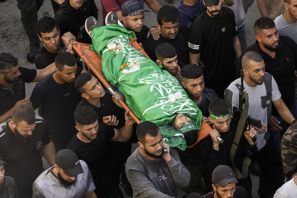 Palestinians carry the bodies of a militant killed in clashes during an Israeli military raid, Jenin refugee camp, West Bank, Friday, Nov. 10, 2023. (AP Photo/Majdi Mohammed)