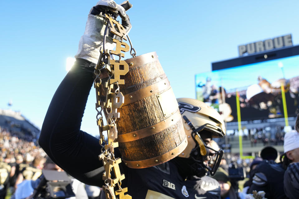 Purdue offensive lineman Mahamane Moussa (77) carries the Old Oaken Bucket as he and teammates celebrates after Purdue defeated Indiana in an NCAA college football game in West Lafayette, Ind., Saturday, Nov. 25, 2023. Purdue defeated Indiana 35-31. (AP Photo/Michael Conroy)