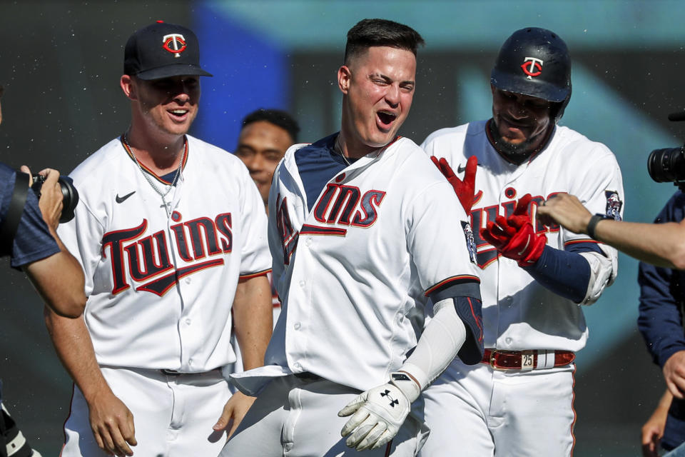 Minnesota Twins' Jose Miranda, center, celebrates between Emilio Pagan, left, and Byron Buxton after he drove in the winning run against the Baltimore Orioles during the ninth inning of a baseball game Saturday, July 2, 2022, in Minneapolis. The Twins won 4-3. (AP Photo/Bruce Kluckhohn)