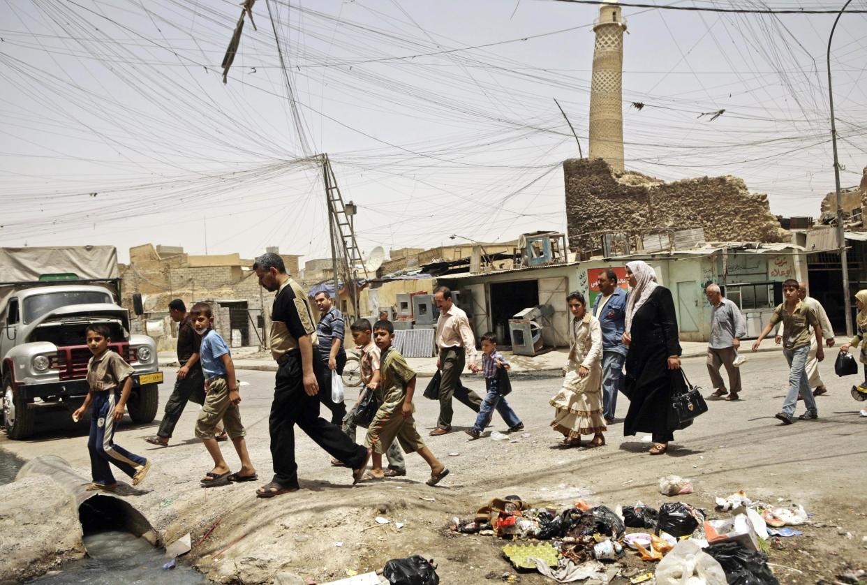 The famous mosque is seen behind this crowd in Mosul: AP