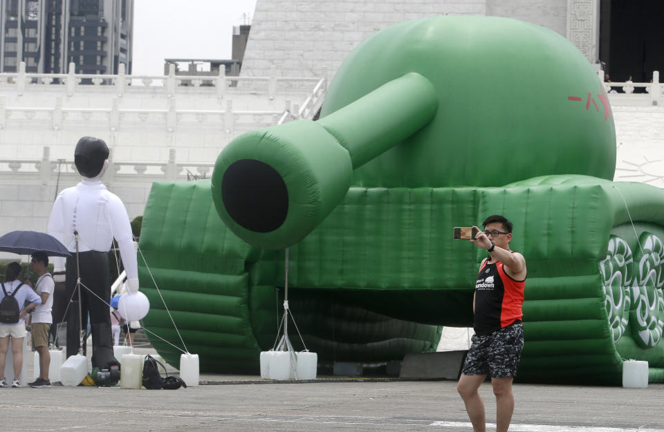 A Taiwanese man takes a selfie with an inflatable tank man at the Liberty Square of Chiang Kai-shek Memorial Hall in Taipei, Taiwan, Saturday, June 1, 2019. An artist erected the inflatable display in Taiwan’s capital to mark an iconic moment in the Tiananmen Square pro-democracy protests. The larger-than-life balloon installation, which stands in front of Taipei’s famous hall, portrays a peaceful encounter between a Chinese civilian and the military tanks that contributed to a brutal shutdown of the demonstrations in Beijing on June 4, 1989. (AP Photo/Chiang Ying-ying)