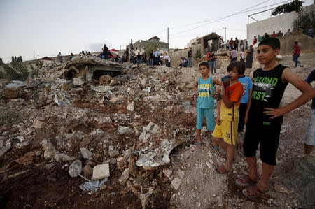 Palestinian boys stand next to the rubble of a house which was destroyed by Israeli troops during an Israeli raid in the West Bank city of Jenin September 1, 2015. REUTERS/Mohamad Torokman