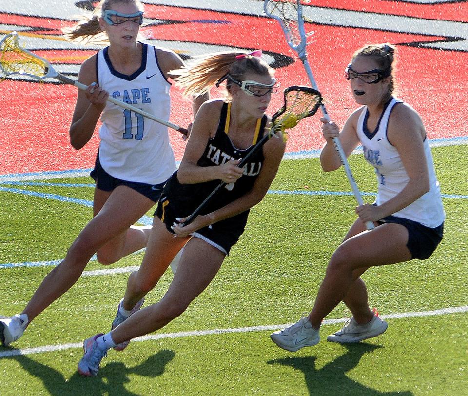 Tatnall's Kali Clayton spins around a pair of Cape Henlopen defenders for a shot at goal in the first half.
