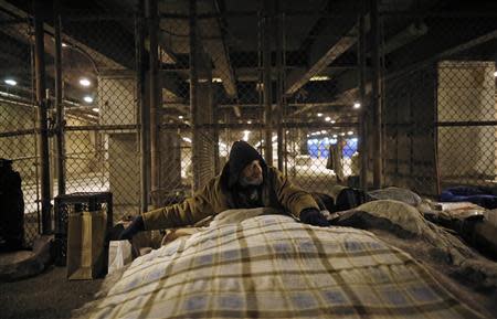 A homeless man sits up in a make-shift bed under the overpasses on Lower Wacker Drive in Chicago, Illinois, January 7, 2014. REUTERS/Jim Young