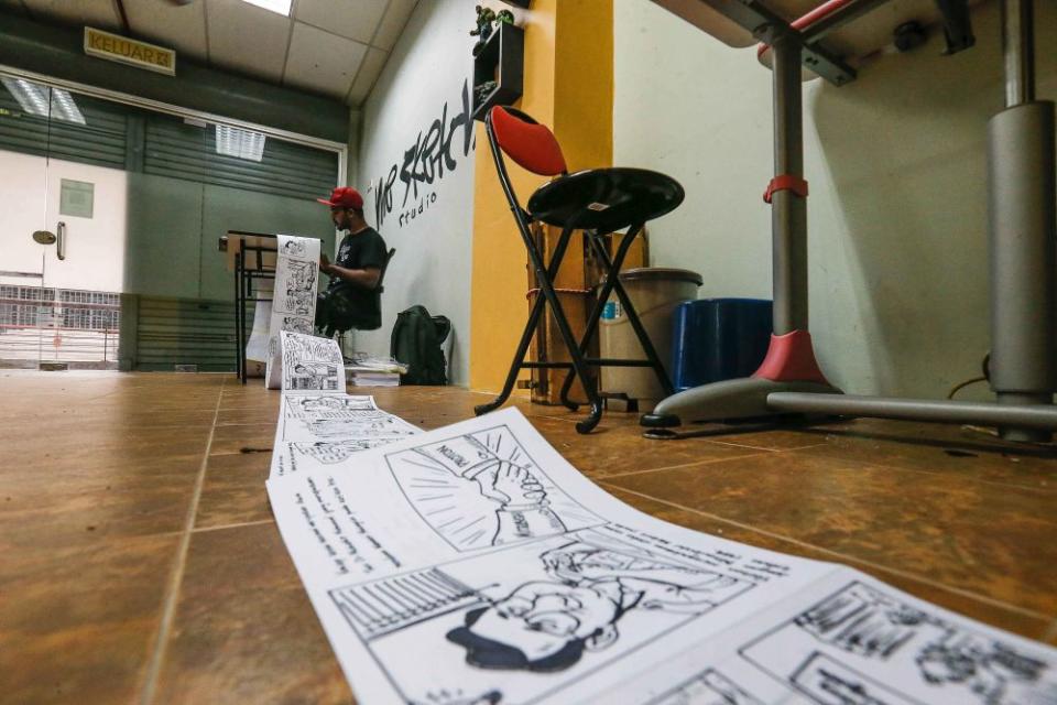 Mohd Azmi at work on his 150-metre comic strip. — Picture by Sayuti Zainudin