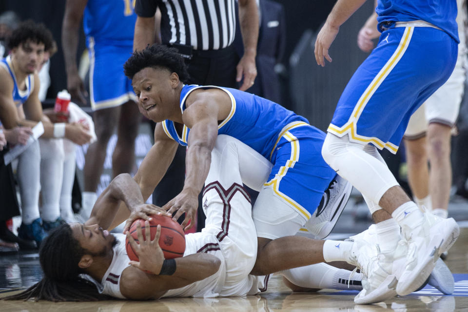 UCLA guard Peyton Watson, top, fights for control of the ball with Bellarmine guard Dylan Penn during the first half of an NCAA college basketball game Monday, Nov. 22, 2021, in Las Vegas. (AP Photo/Ellen Schmidt)