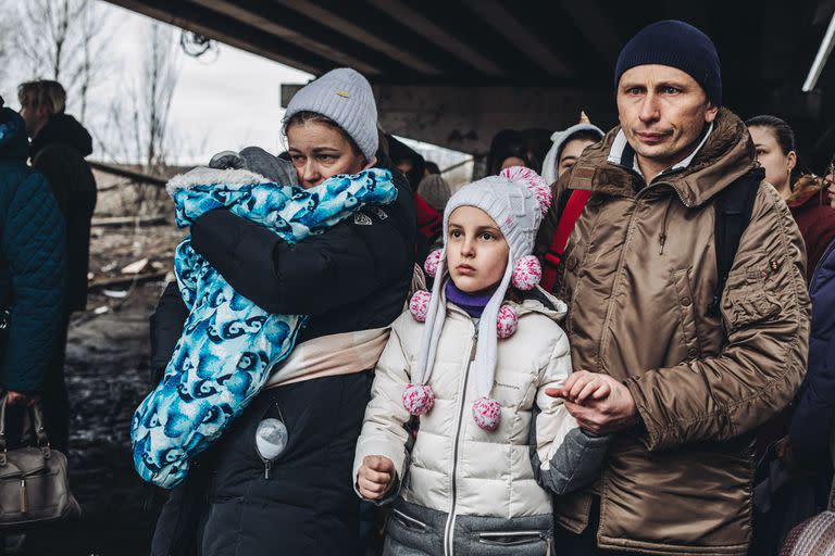 05-03-2022 Varias personas con niños esperan para cruzar el río de Irpin, a 5 de marzo de 2022, en Irpin (Ucrania). El ejército de Ucrania resiste por el momento el duro asedio de Rusia a su capital, Kiev, donde se recrudecen los combates. Naciones Unidas calcula que este domingo, 6 de marzo, el número de refugiados ucranios podría ascender a 1,5 millones. El número de civiles muertos en el conflicto se acerca a los 3.000 y casi 4.000 heridos según fuentes del gobierno ucraniano.  Después de que Visa y Mastercard se unieran  a la lista de empresas que están cerrando sus filiales en Rusia, Putin dijo que las sanciones impuestas por Occidente y sus compañías  son «una declaración de guerra». Además el presidente ruso  firmó un decreto por el que ordena al Consejo de Ministros elaborar un listado de países que han realizado «acciones no amistosas». POLITICA Diego Herrera - Europa Press