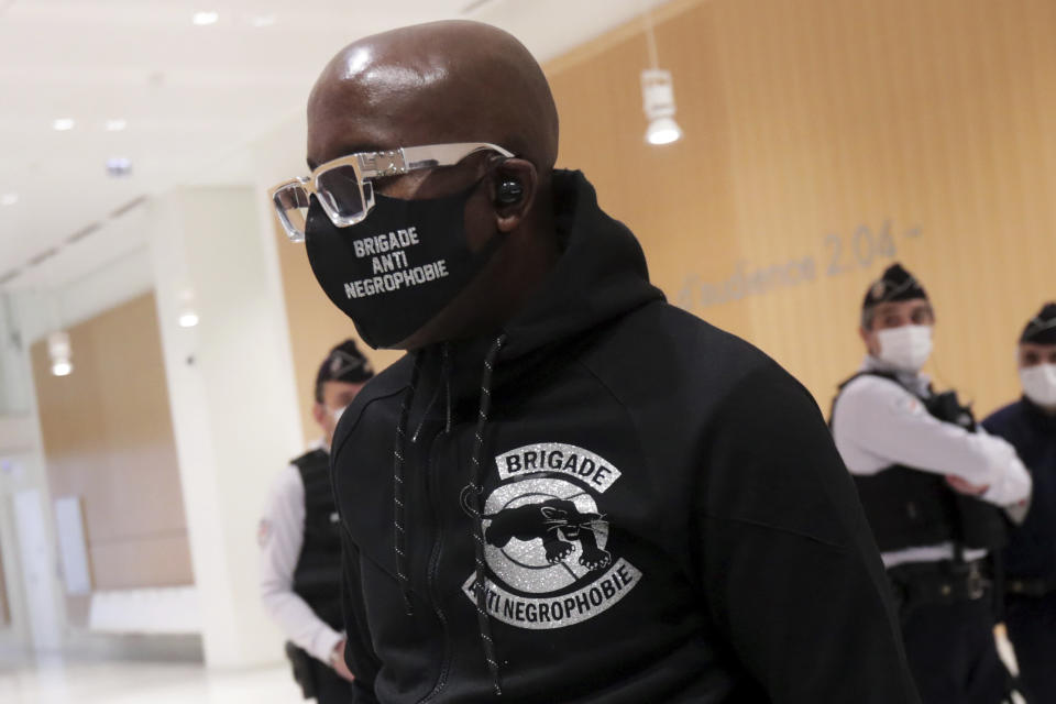 An activist from a group called the Anti-Negrophobia Brigade, Franco Lollia, wears a face mask reading « Anti-Negrophobia Brigade » as he arrives at the Paris courthouse, in Paris, May 10, 2021. Lollia stands accused of covering in graffiti a statue that honours Jean-Baptiste Colbert, a 17th century royal minister who wrote rules governing slaves in France's overseas colonies. (AP Photo/Thibault Camus)