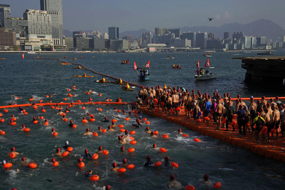 Competitors swim during a harbor race at the Victoria Harbor in Hong Kong, Sunday, Dec. 12, 2021. Hundreds of people took part in traditional swim across iconic Victoria Harbor after two years of suspension. (AP Photo/Kin Cheung)