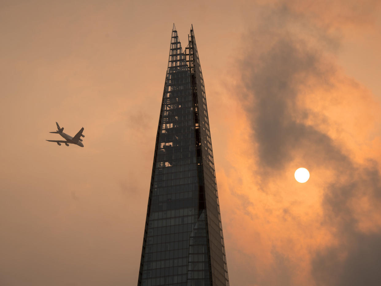 A plane flies past the Shard in central London: PA