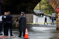 Federal Bureau of Investigation (FBI) officials and police officers walk near the area where an explosive device left at a train station was detonated by the authorities in Elizabeth, New Jersey, U.S., September 19, 2016. REUTERS/Eduardo Munoz