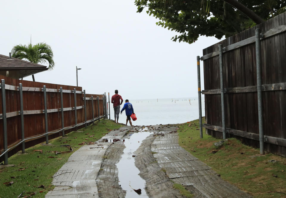 Residents look at a downed U.S. Navy aircraft in Kaneohe Bay, Monday, Nov. 20, 2023, in Kaneohe, Hawaii. (Jamm Aquino/Honolulu Star-Advertiser via AP)