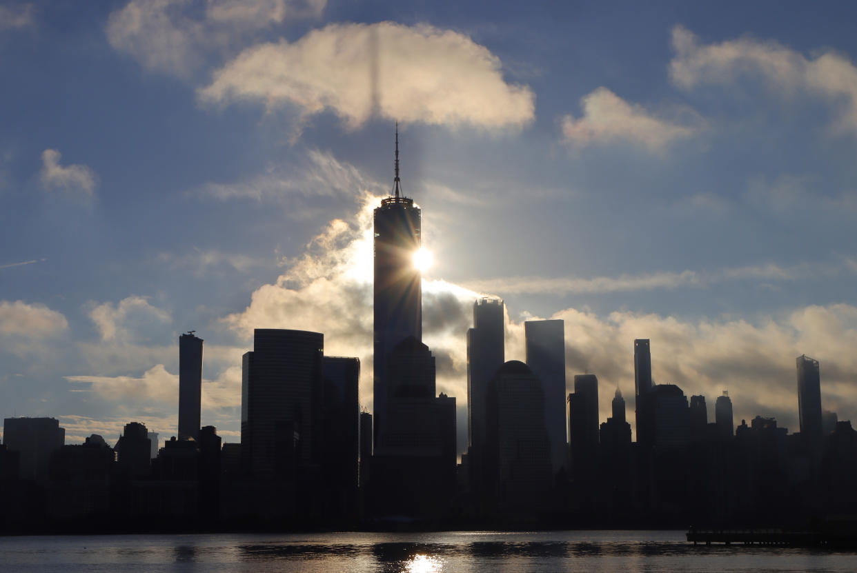 JERSEY CITY, NJ - OCTOBER 31: One World Trade Center casts a shadow on a passing cloud as the sun rises on Halloween in New York City on October 31, 2021 as seen from Jersey City, New Jersey. (Photo by Gary Hershorn/Getty Images)