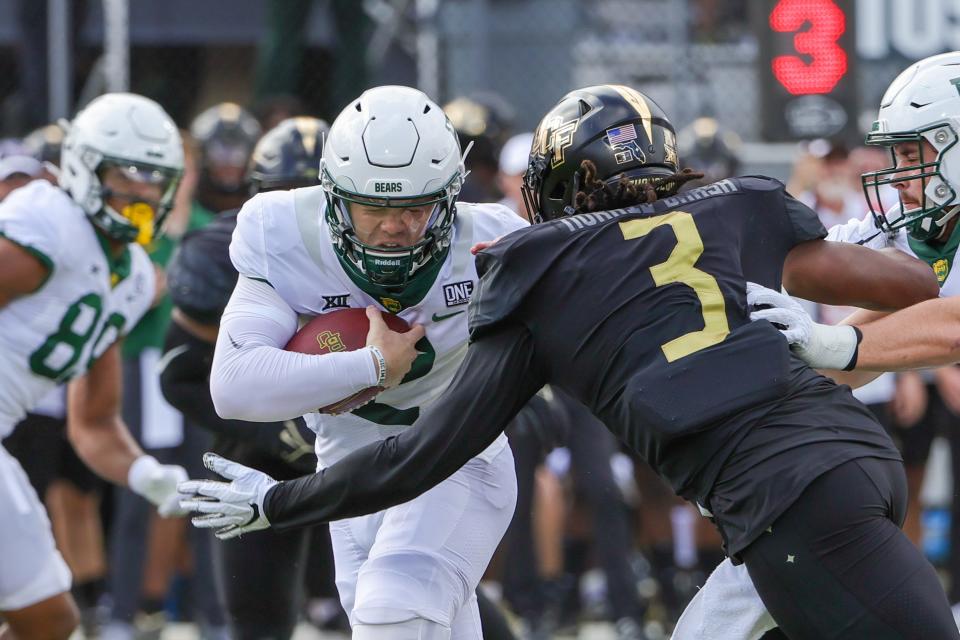 Baylor Bears quarterback Blake Shapen (12) runs the ball as UCF Knights defensive end Tre'Mon Morris-Brash (3) moves in for the sack during the first quarter Sept. 30, 2023, at FBC Mortgage Stadium in Orlando, Florida.