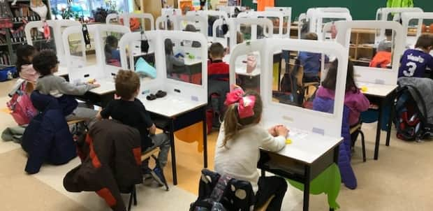 Children in Grade 1 at Steve MacLean Public School in Ottawa sit behind protective barriers in the classroom. Teachers are worried as variant cases rise in the city. (Submitted by Lisa Levitan - image credit)